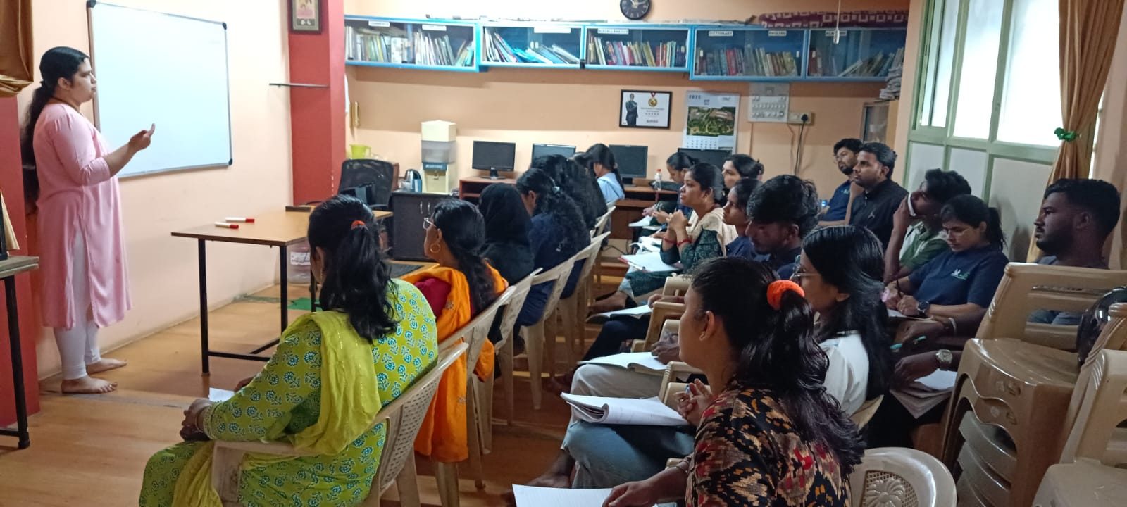 Teacher explaining on the whiteboard to a full classroom