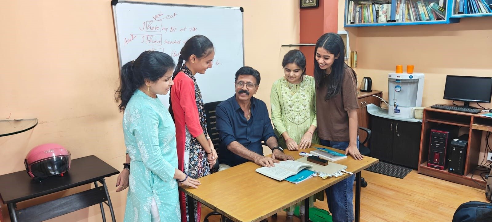 Students and trainer reviewing a course book together