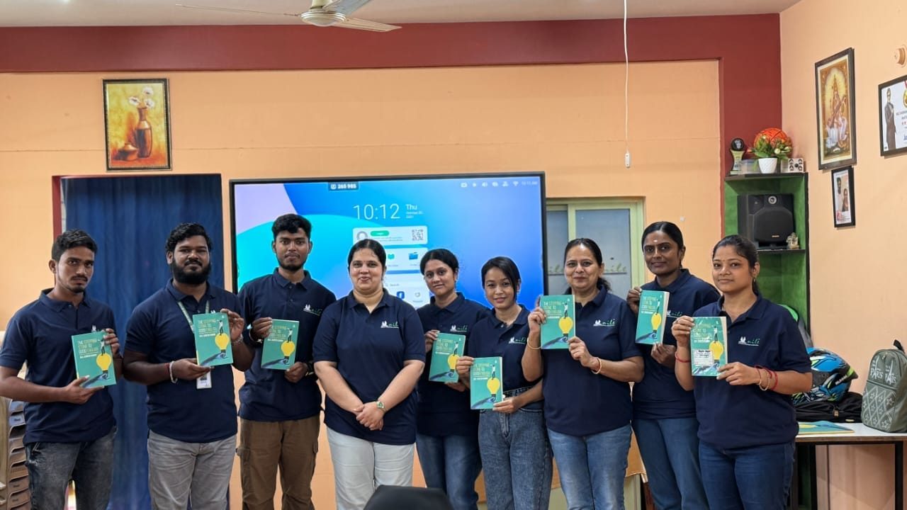 The Nile team holding their course books in front of the smart board