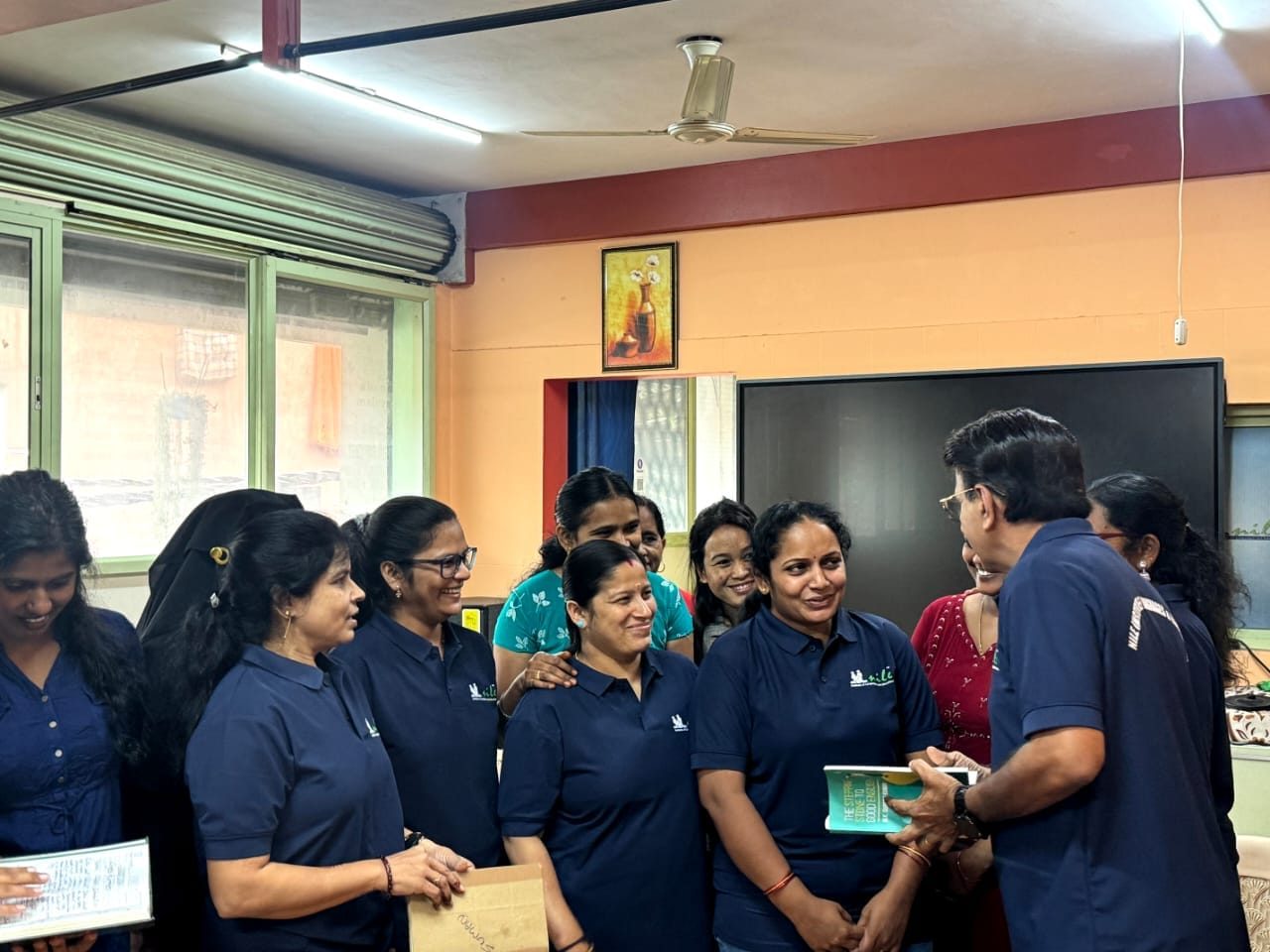 Nile team members with a colleague sharing a book